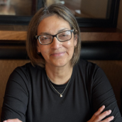 Woman with glasses in black blouse. 