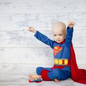 A little boy dressed as a superhero.