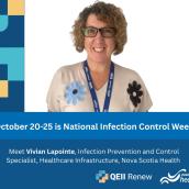 A woman with short, dark blonde hair wears glasses and a lanyard and a white shirt with flowers, smiling at the camera.