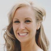 The portrait-style image features a woman with a joyful expression smiling at the camera.