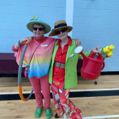 Two women wearing stylish hats are standing indoors.