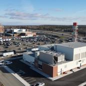 A drone shot of a hospital, parking lot, and a facility under construction in the background.