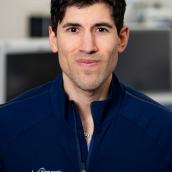 Dr. Jhase Sniderman looking directly at camera. He has dark hair and is wearing a Nova Scotia Health shirt.