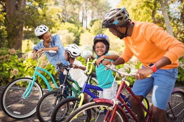 Family of four biking together wearing helmets
