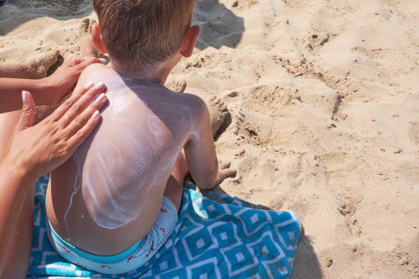 Applying sunscreen on child's back