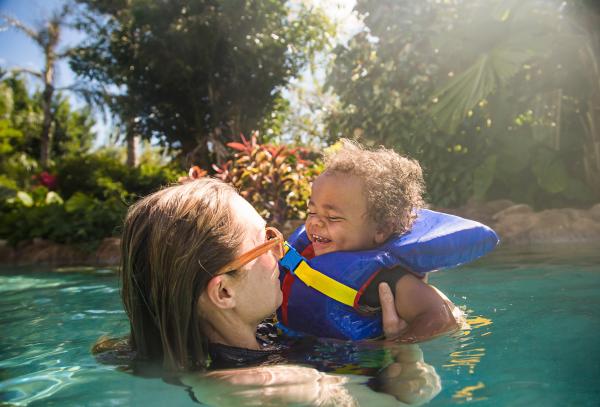 Mom swimming with child in a lifejacket