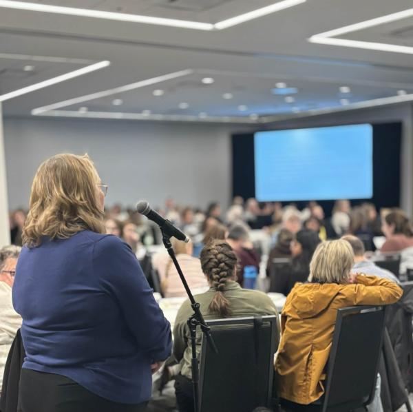 An attendee poses a thoughtful question for Dr. Paige Moorhouse during the Goals of Care presentation.