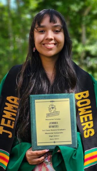 Outdoors with trees in the background, a smiling woman holds a certificate.
