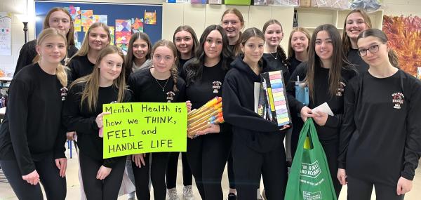 A group of girls stand together indoors, capturing a sense of camaraderie among the group.