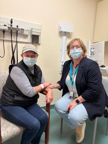 Two women (patient and a doctor) sitting next to each other in a clinic room.