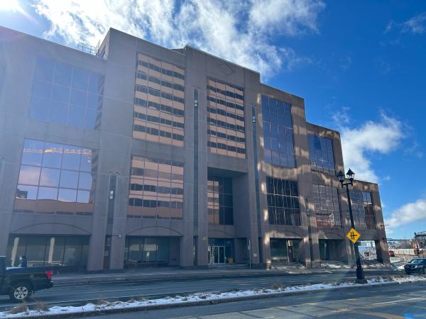 Image of a large building from the outside. The roof has different heights and layers.