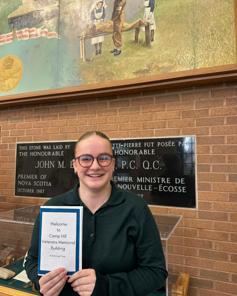 Image of a person wearing glasses holding a certificate in their hand.