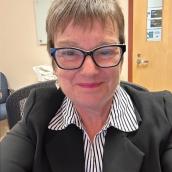 A photo of Valerie Nugent, on her own, smiling at the camera. 