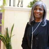Professional looking middle-aged woman standing in a bright room.