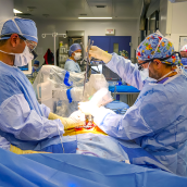 Surgeons and healthcare staff operate on a patient using surgical robot