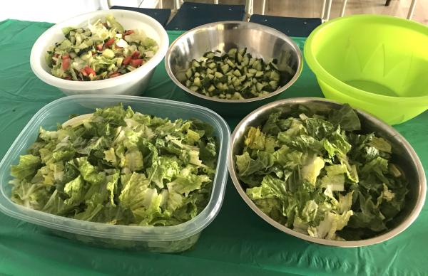 An indoor setting of a group of bowls filled with various salads is arranged on a table. 