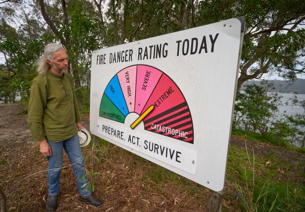 Man looking at sign that shows fire danger rating 