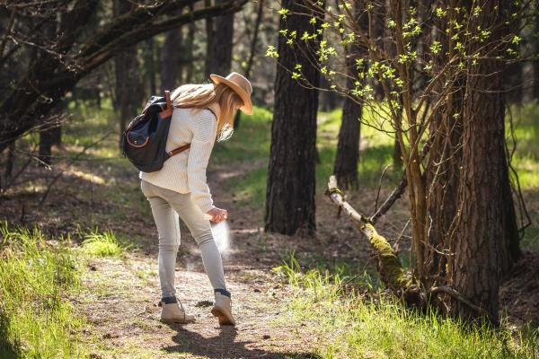 A woman putting on bug spray