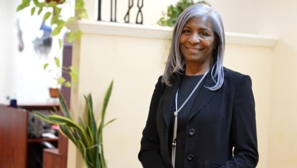 Professional looking middle-aged woman standing in a bright room.
