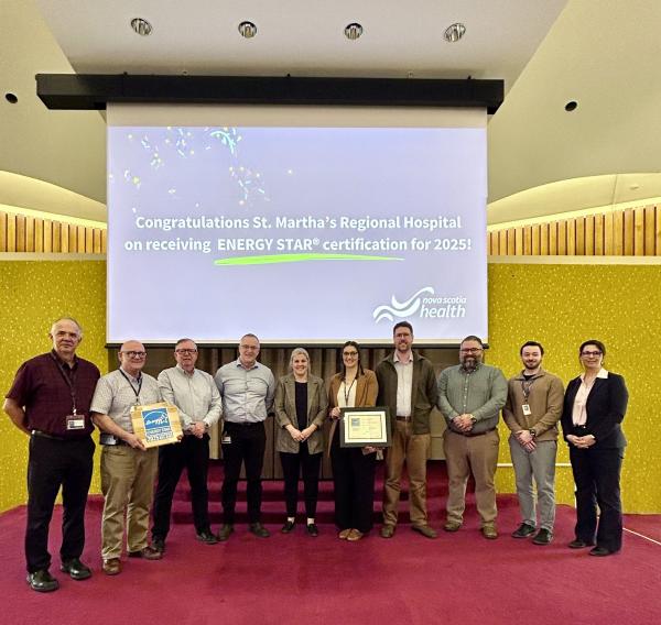 A group of people posed for a photo with two members of the group holding awards. 