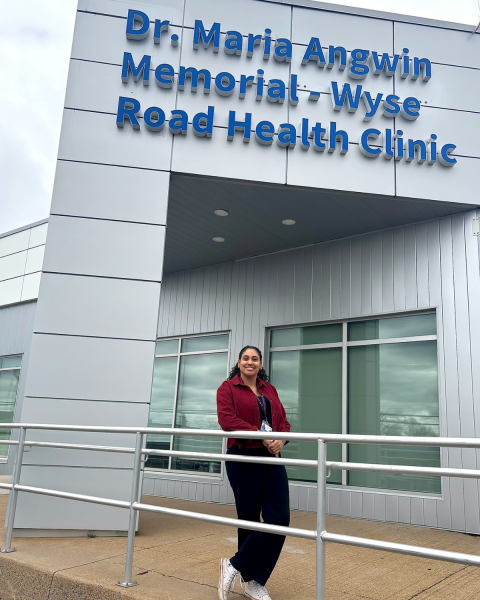 Picture of a woman standing outside a building Dr. Maria Angwin Memorial - Wyse Road Health Clinic.