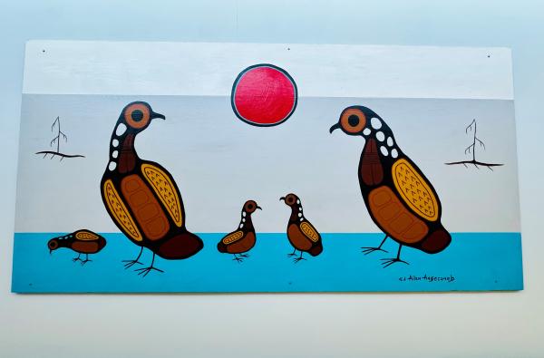A photo of Indigenous artwork of five birds hangs in a hospital hallway. 