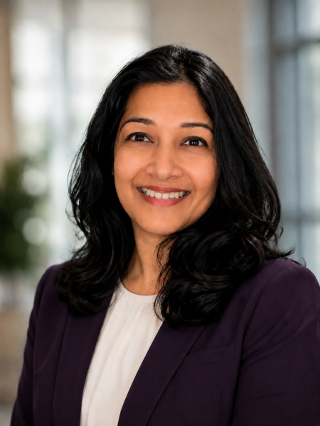 Professional headshot of Dr. Muna Chowdhury. Dr. Chowdhury is a woman with long dark hair, a white shirt and black blazer.
