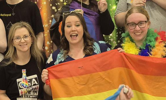 Three Youth Health Centre coordinators holding Pride flag