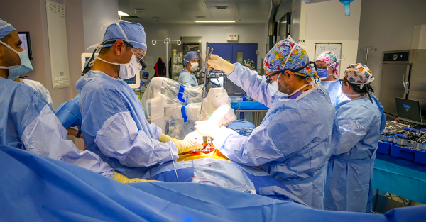 Surgeons and healthcare staff operate on a patient using surgical robot