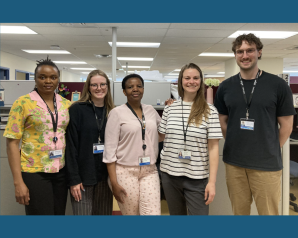 Image of 4 female healthcare workers and one male. They are all wearing lanyards around their neck with photo id's attached.